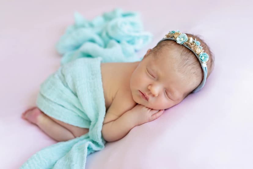 Marcelin stylizovaný newborn portrét, miminko v jemném tyrkysovém wrapu s květinovou čelenkou, ateliér v Čechyni nedaleko Brna