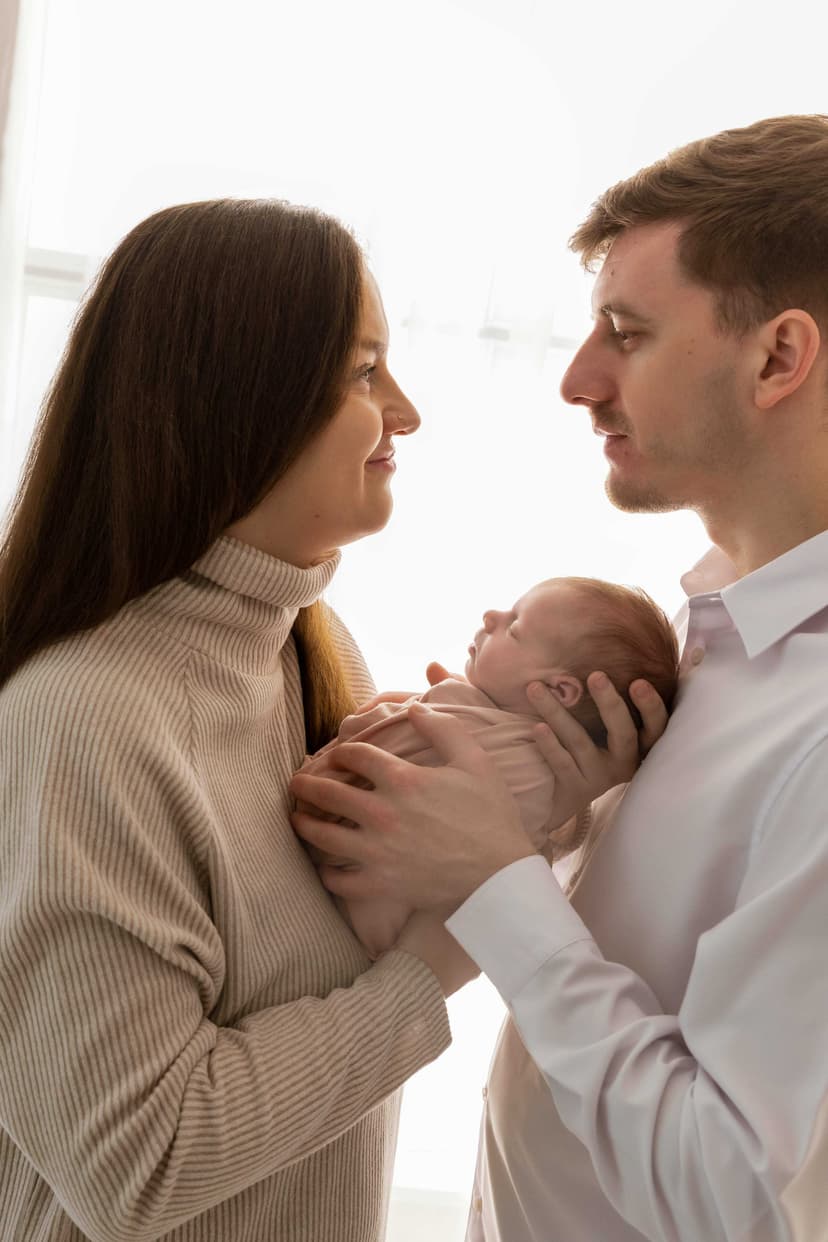 Newborn focení Brno, rodiče drží novorozeně v náručí v ateliéru v Čechyni nedaleko Brna, klid a doteky prvních dní