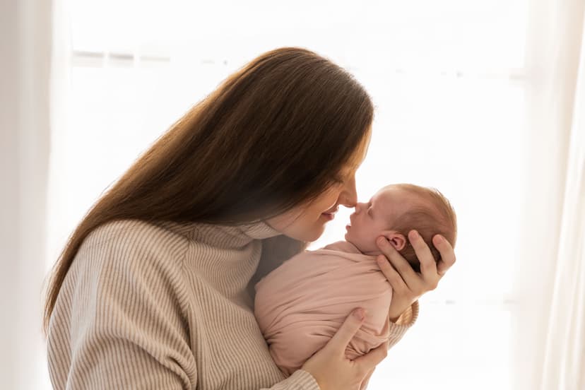 Newborn focení Brno, maminka drží miminko v náručí v ateliéru v Čechyni nedaleko Brna, autentický rodinný moment v jemném světle