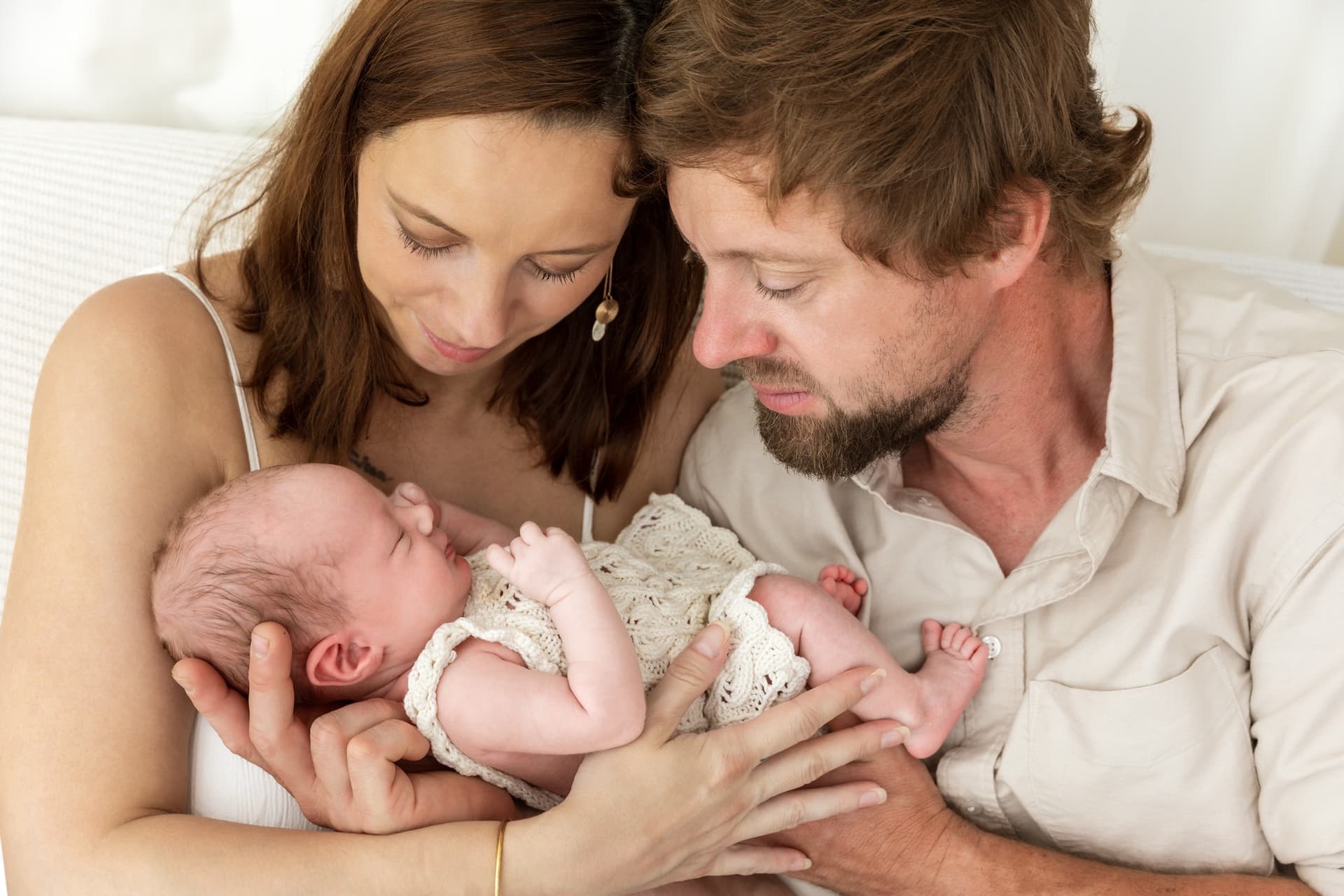 Newborn focení Brno, rodiče v objetí s novorozenou Josefínkou v ateliéru v Čechyni nedaleko Brna, klidné rodinné focení